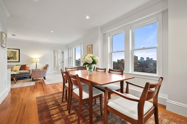 dining space with a wealth of natural light, hardwood / wood-style floors, and ornamental molding