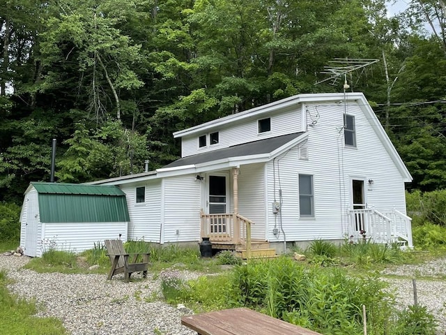 rear view of house featuring an outbuilding