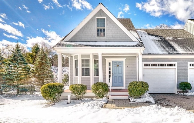 view of front of property with a shingled roof, decorative driveway, and an attached garage