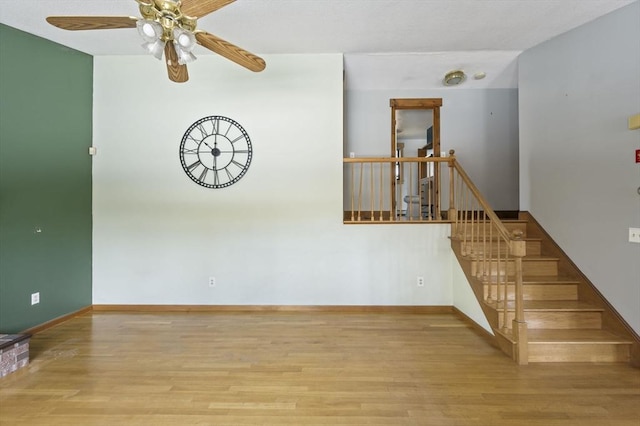 staircase featuring hardwood / wood-style floors and ceiling fan