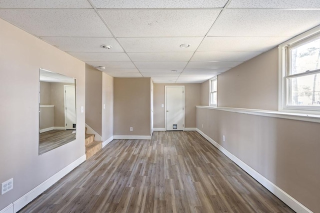 spare room featuring hardwood / wood-style floors and a drop ceiling