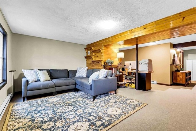 carpeted living area featuring baseboards, a textured ceiling, and a baseboard heating unit