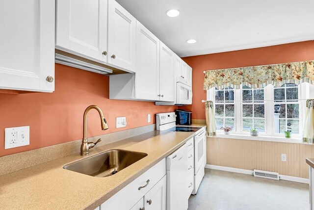 kitchen with white cabinets, visible vents, light countertops, white appliances, and a sink