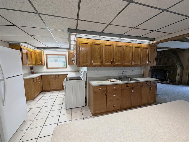 22 Newton Ave, Tewksbury, MA 01876 - kitchen with freestanding refrigerator, stove, brown cabinets, light countertops, and a paneled ceiling