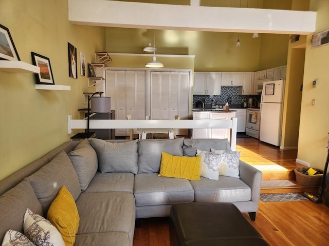 living room featuring light hardwood / wood-style flooring and a towering ceiling