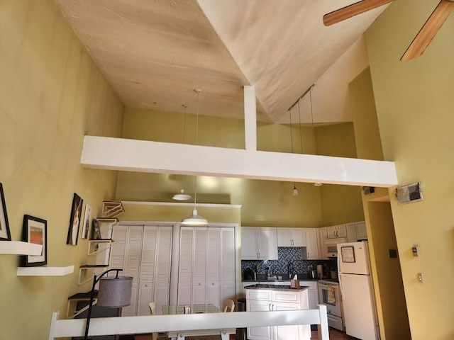 kitchen with tasteful backsplash, a high ceiling, and white fridge