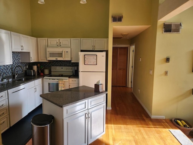 kitchen featuring sink, white appliances, white cabinets, and light hardwood / wood-style floors