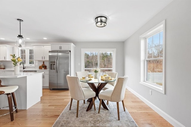 dining space with recessed lighting, a healthy amount of sunlight, light wood finished floors, and baseboards
