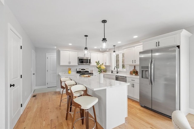 kitchen with white cabinetry, stainless steel appliances, and a sink