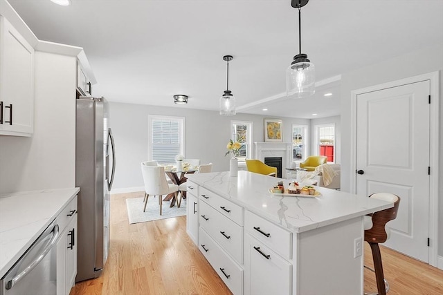 kitchen with recessed lighting, a center island, stainless steel appliances, and light wood-style floors
