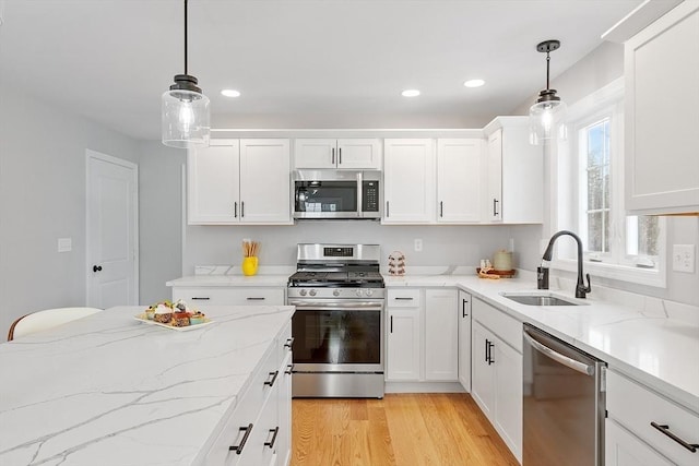 kitchen with recessed lighting, stainless steel appliances, a sink, light wood-style flooring, and white cabinetry
