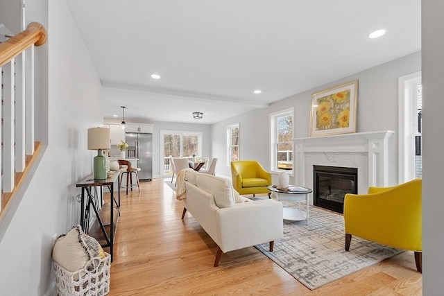 living area with a fireplace, light wood finished floors, and recessed lighting