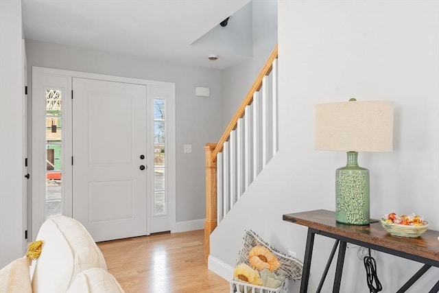 entrance foyer with stairway, baseboards, and wood finished floors
