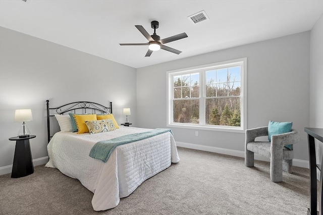 carpeted bedroom with visible vents, a ceiling fan, and baseboards