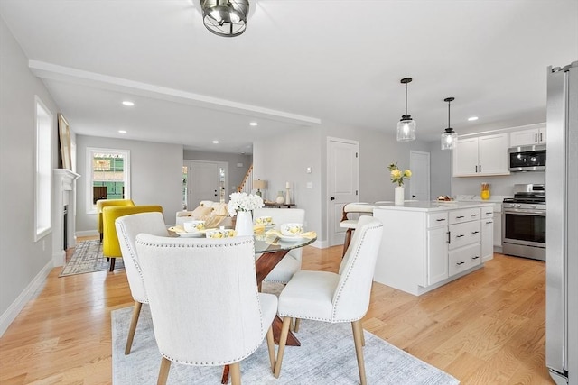 dining room with recessed lighting, light wood-style floors, and baseboards