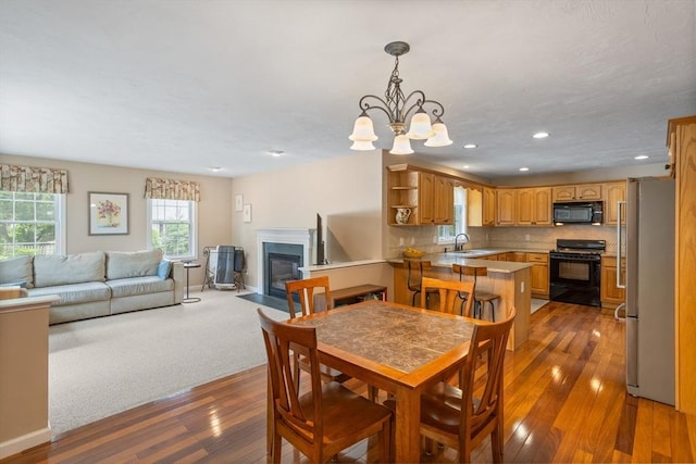 45 Taylor Rd, Maynard, MA 01754 - dining area with wood-type flooring, a fireplace with flush hearth, a chandelier, recessed lighting, and baseboards