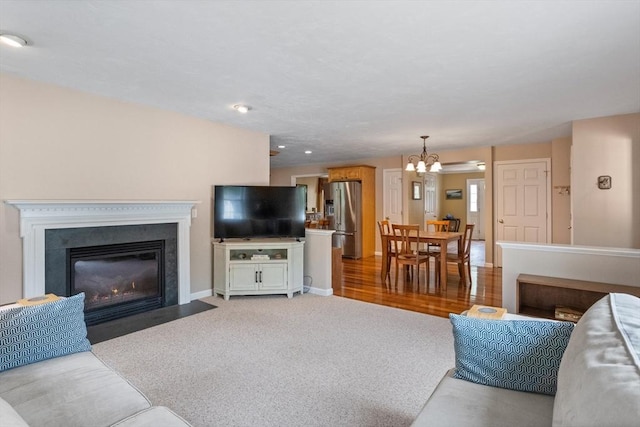45 Taylor Rd, Maynard, MA 01754 - living area with a chandelier, a fireplace with flush hearth, light colored carpet, and baseboards