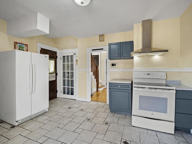 kitchen featuring blue cabinets, wall chimney exhaust hood, white appliances, and light countertops