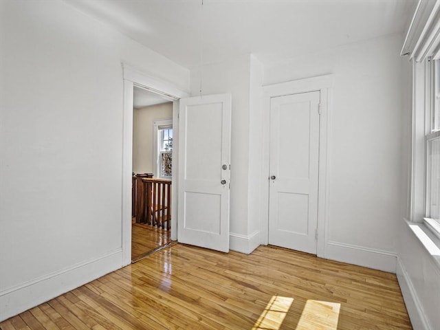 interior space with baseboards, plenty of natural light, and light wood-type flooring