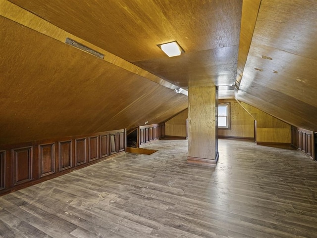 additional living space featuring wooden walls, vaulted ceiling, wooden ceiling, and wood finished floors