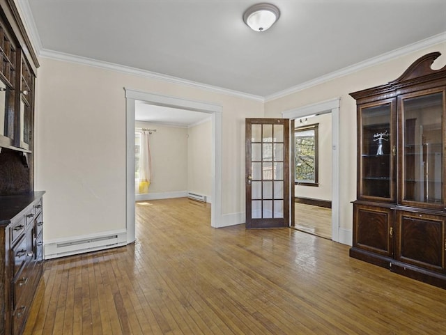 unfurnished dining area featuring crown molding, hardwood / wood-style floors, and a baseboard radiator