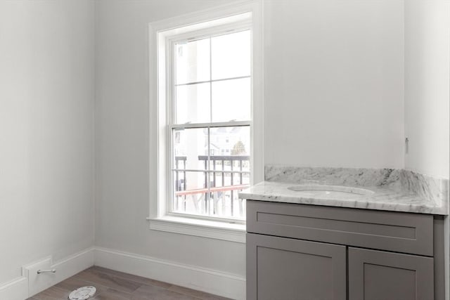 bathroom featuring vanity, baseboards, and wood finished floors