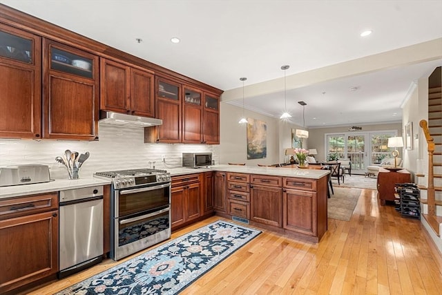 49 Intrepid Cir Unit 49, Marblehead, MA 01945 - kitchen featuring stainless steel appliances, under cabinet range hood, a peninsula, light countertops, and light wood-style floors