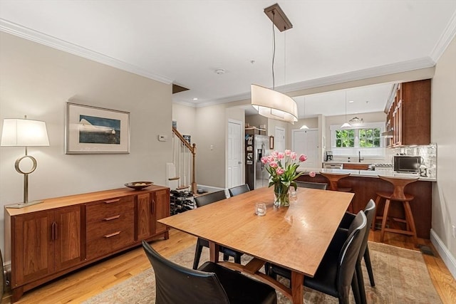 49 Intrepid Cir Unit 49, Marblehead, MA 01945 - dining area featuring light wood-style flooring, crown molding, and stairway