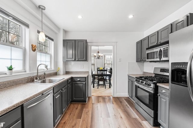 47 Moffatt Rd, Salem, MA 01970 - kitchen featuring stainless steel appliances, a chandelier, light wood-style floors, gray cabinets, and hanging light fixtures