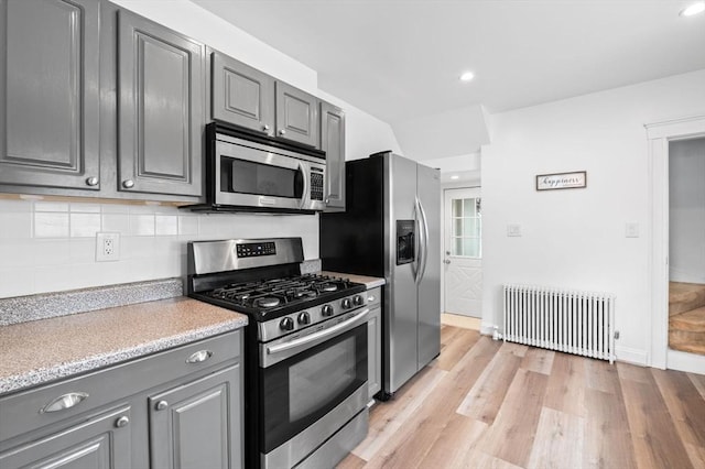 47 Moffatt Rd, Salem, MA 01970 - kitchen with stainless steel appliances, radiator heating unit, gray cabinets, light countertops, and backsplash