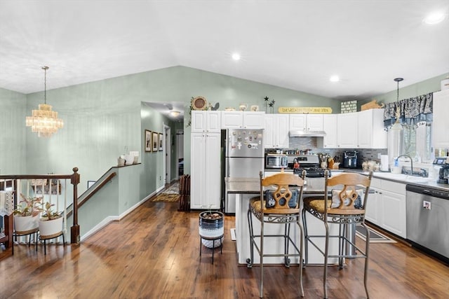 64 Ventura Ln, New Bedford, MA 02745 - kitchen featuring appliances with stainless steel finishes, a chandelier, lofted ceiling, white cabinetry, and a kitchen bar