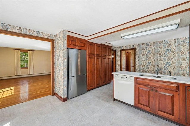 kitchen with stainless steel refrigerator, a baseboard radiator, wallpapered walls, a sink, and dishwasher