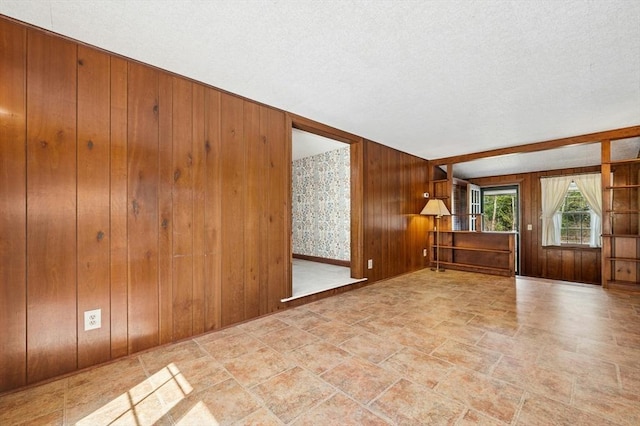 empty room with wooden walls and stone finish floor