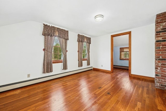 unfurnished room with plenty of natural light, wood finished floors, and baseboard heating
