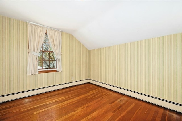 additional living space featuring wallpapered walls, wood finished floors, and lofted ceiling