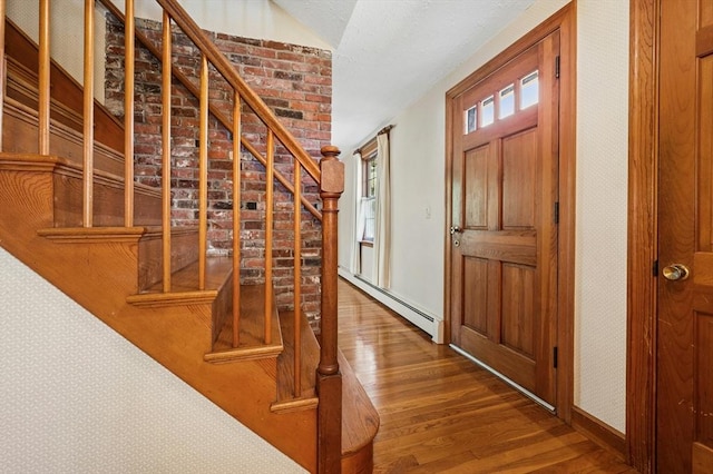 entrance foyer with baseboards, a baseboard radiator, stairs, and wood finished floors