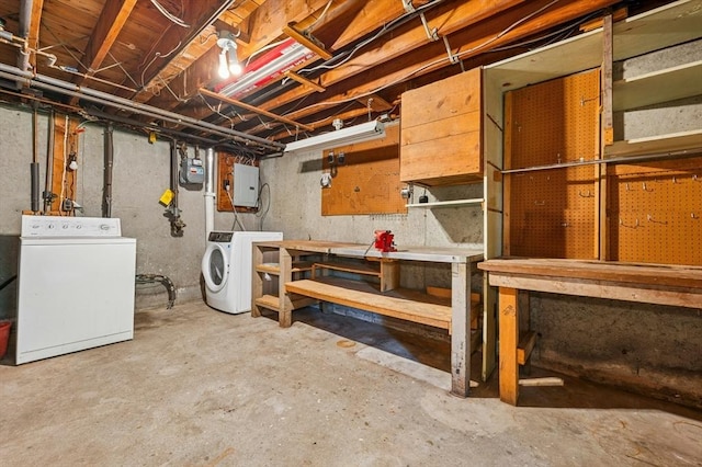 unfinished below grade area featuring a workshop area and washing machine and clothes dryer