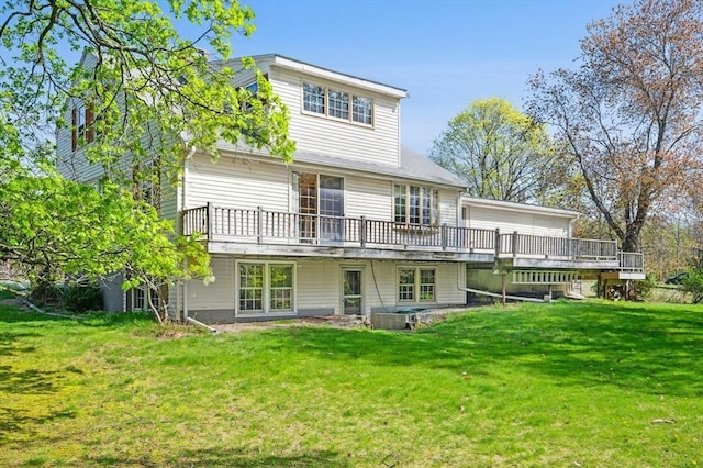 rear view of house featuring a lawn and a deck