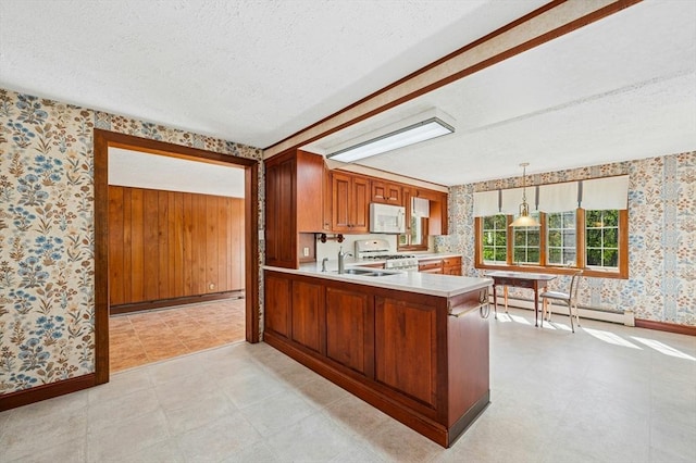 kitchen featuring baseboard heating, brown cabinets, light countertops, wallpapered walls, and white appliances
