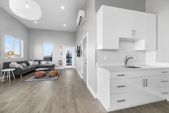 kitchen with white cabinetry, sink, and a wall mounted AC