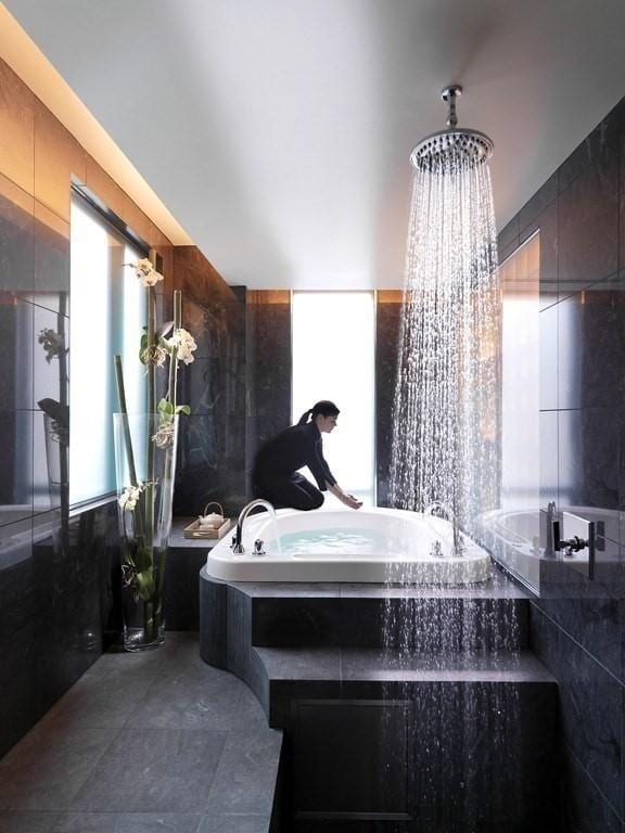 bathroom with tile walls and tiled tub