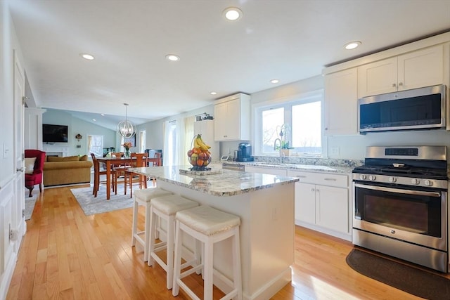 585 Chestnut St, Ashland, MA 01721 - kitchen featuring white cabinetry, vaulted ceiling, stainless steel appliances, and light wood finished floors