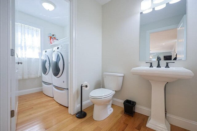 585 Chestnut St, Ashland, MA 01721 - bathroom featuring toilet, baseboards, washing machine and clothes dryer, a sink, and wood finished floors