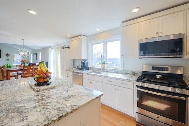 585 Chestnut St, Ashland, MA 01721 - kitchen with a sink, white cabinetry, light stone countertops, appliances with stainless steel finishes, and an inviting chandelier