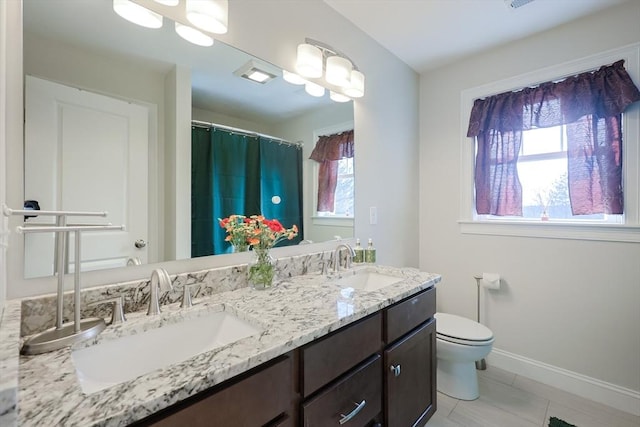 585 Chestnut St, Ashland, MA 01721 - full bathroom featuring double vanity, toilet, baseboards, and a sink