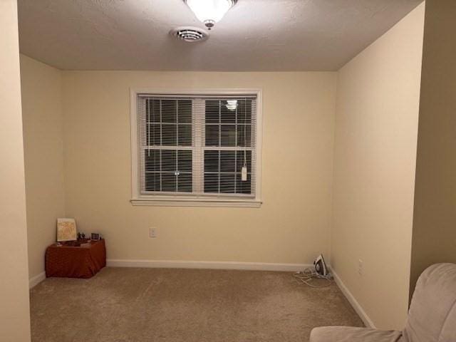 empty room featuring carpet, visible vents, and baseboards