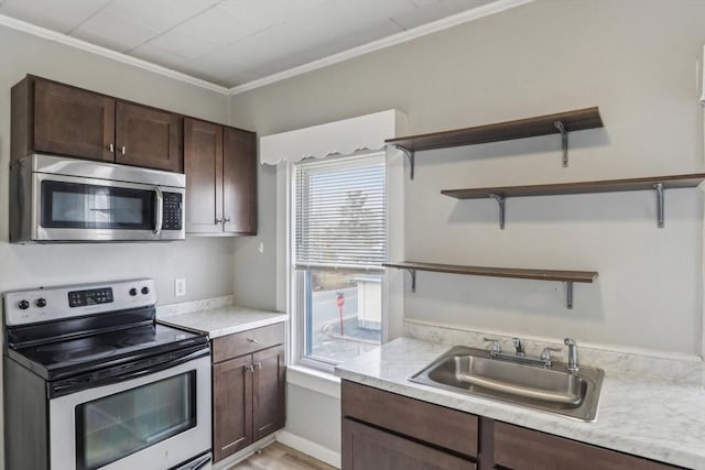 kitchen featuring dark brown cabinetry, a sink, light countertops, appliances with stainless steel finishes, and open shelves