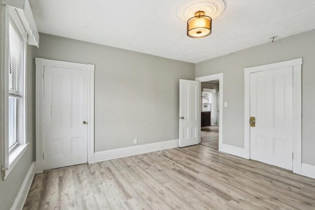 unfurnished bedroom featuring baseboards and wood finished floors