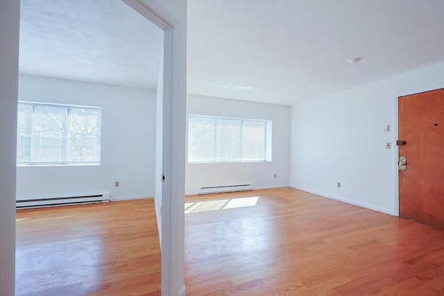 foyer entrance featuring a baseboard radiator, baseboards, and light wood-style flooring