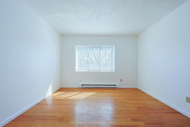 empty room featuring light wood-style flooring, baseboards, and a baseboard radiator